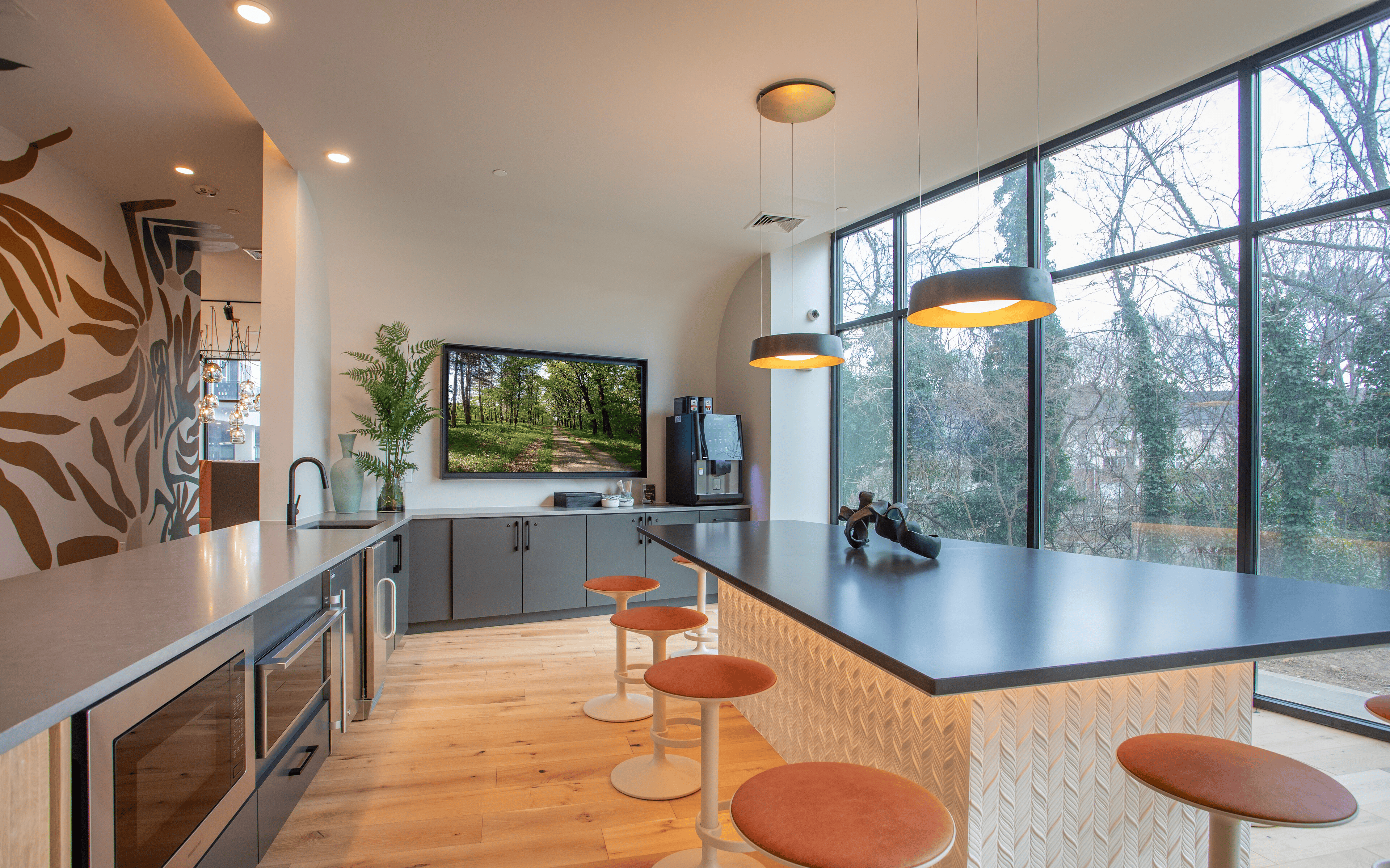 Open concept clubhouse kitchen space with coffee machine at The Row Apartments in Raleigh, NC
