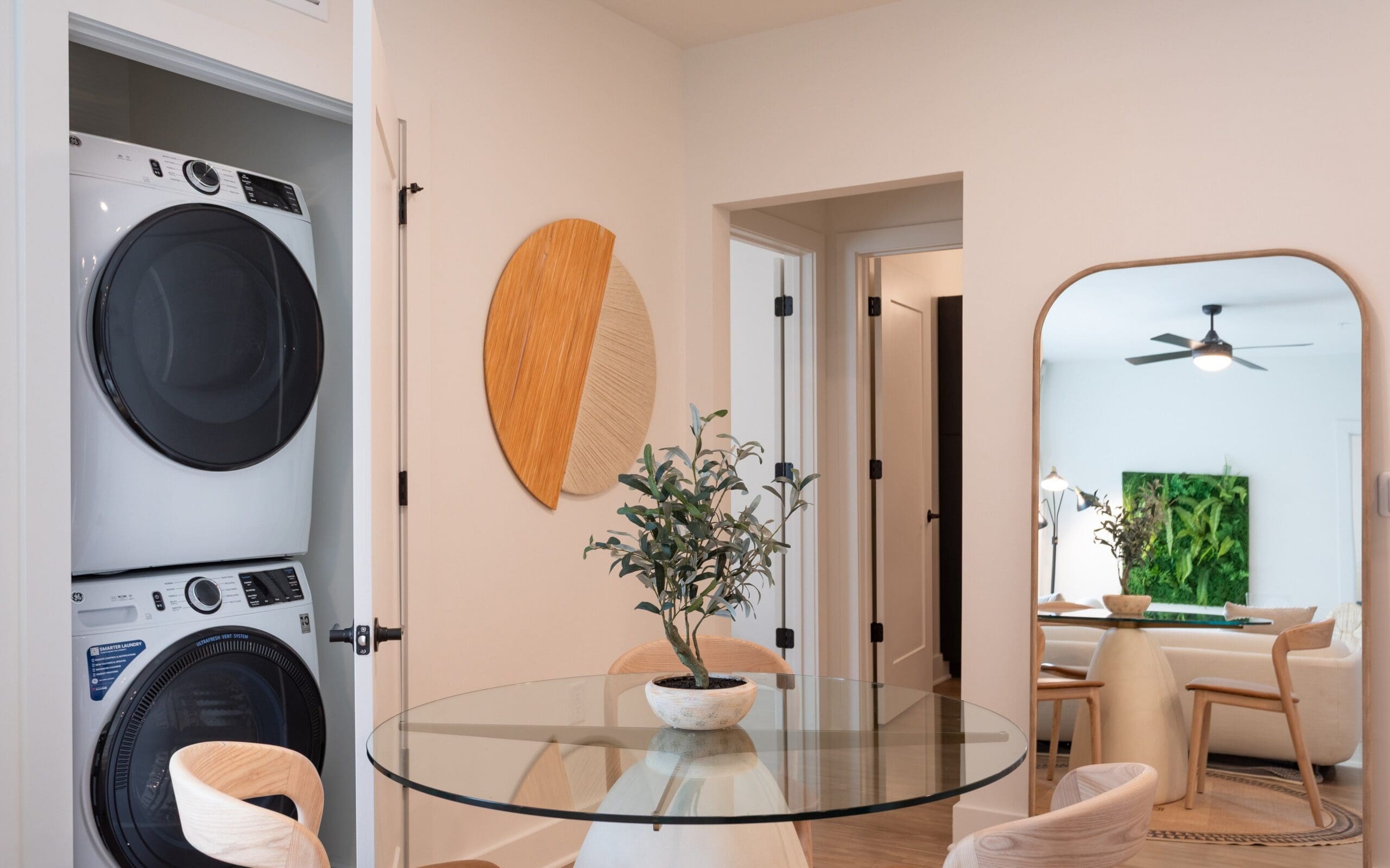 Model living space with table and in unit washer and dryer at The Row apartments in Raleigh, NC